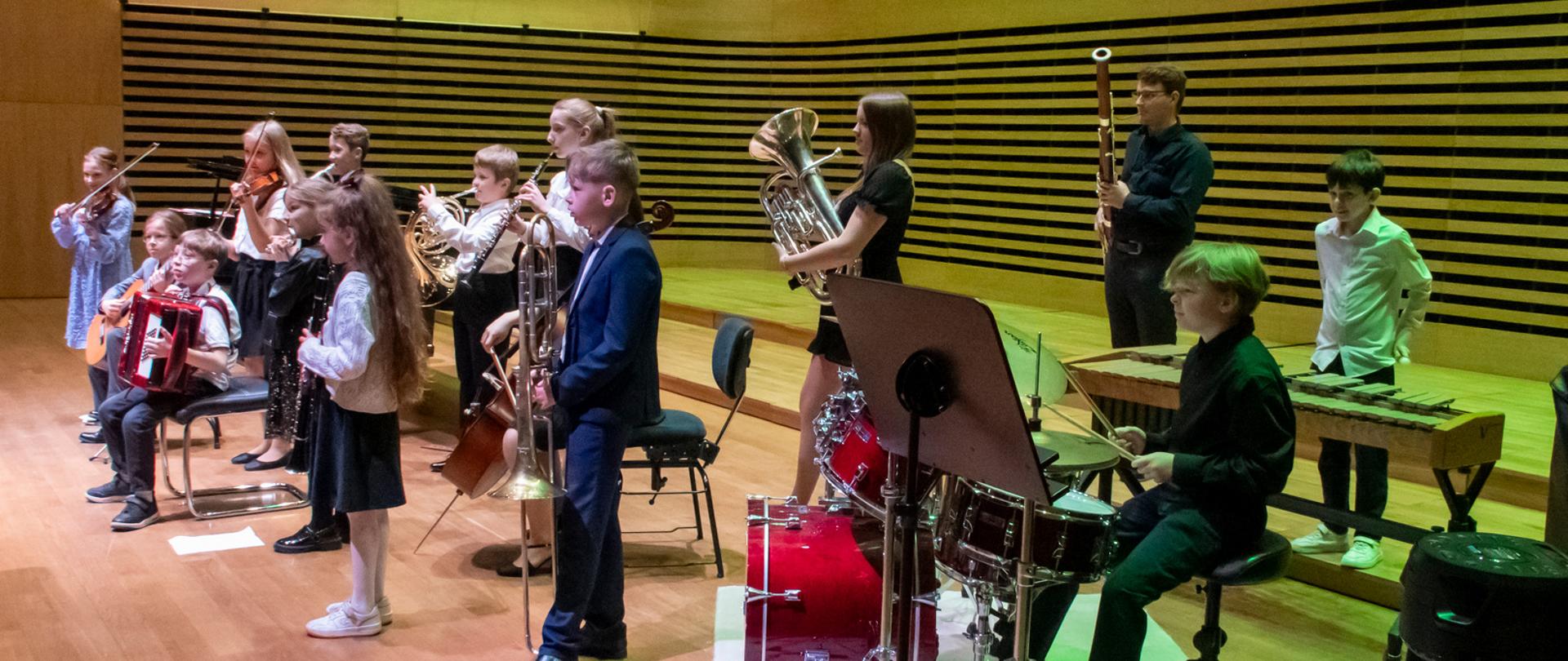 Wszyscy wykonawcy ustawieni na scenie jak w orkiestrze.