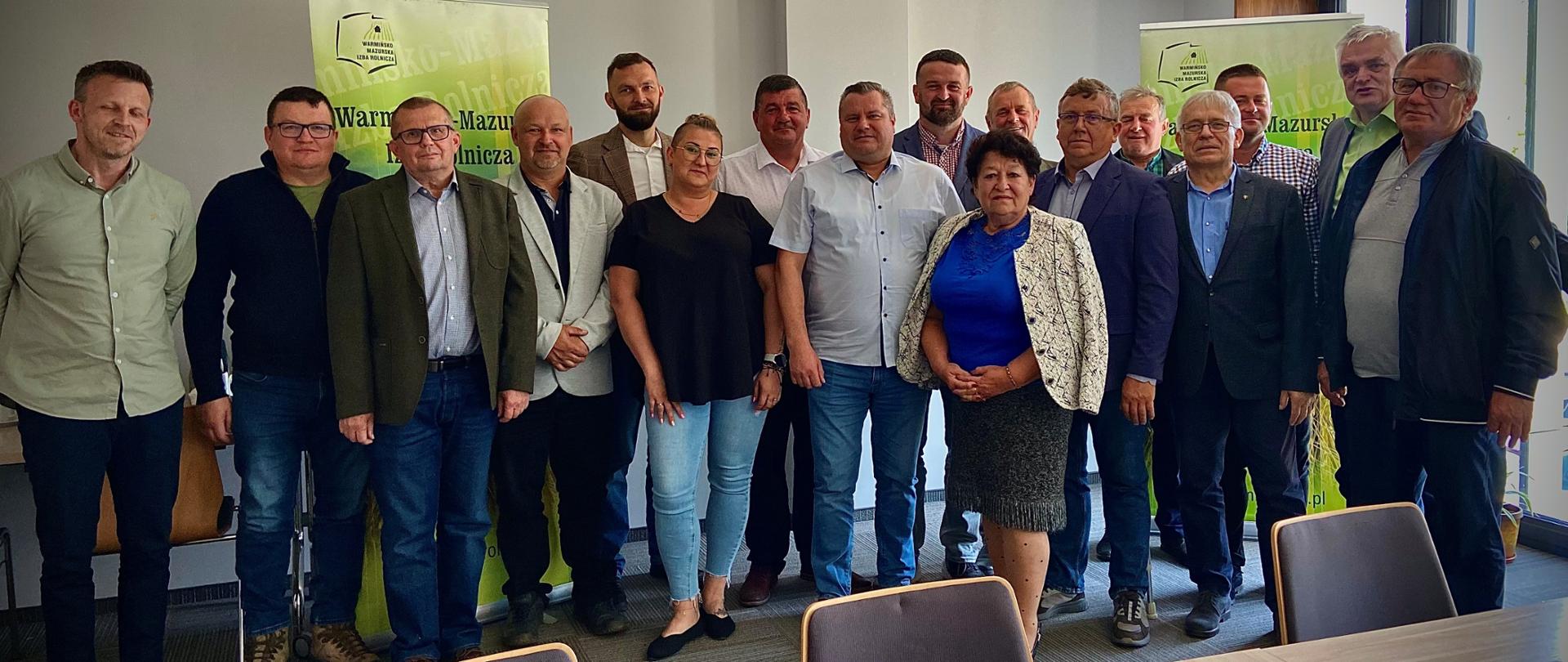 Grupowe zdjęcie uczestników posiedzenia Rady Powiatowej Warmińsko- Mazurskiej
Izby Rolniczej w Elblągu, wykonane w Sali konferencyjnej na tle banerów z logo Izby
