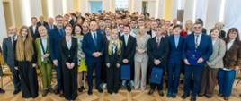 Pamiątkowe zdjęcie grupowe wszystkich uczestników, laureatów i gości w jasnej sali kolumnowej po zakończeniu Gali.