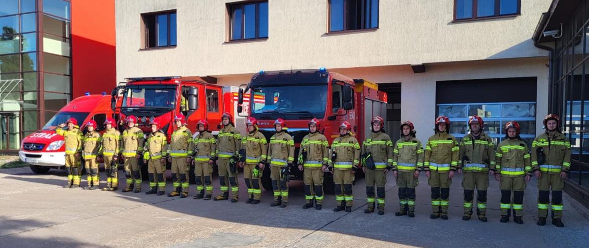 Na zdjęciu widać grupę strażaków, którzy oddają hołd zmarłemu strażakowi KG PSP. 