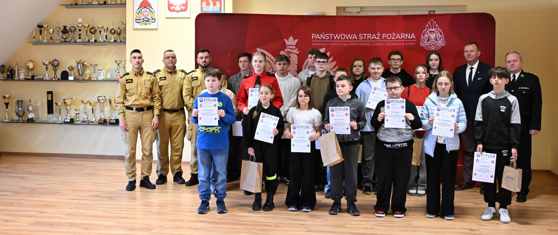 Zdjęcie grupowe uczestników turnieju wraz z osobami funkcyjnymi na ściance