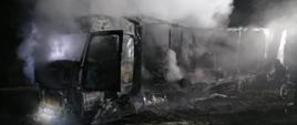 Ciągnik siodłowy z naczepą, który uległ praktycznie całkowitemu spaleniu. Zarówno z kabiny jak i z naczepy unoszą się kłęby pary po podjętych przez strażaków działaniach gaśniczych.