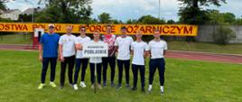 42. Mistrzostwa Polski w Sporcie Pożarniczym zakończone - reprezentacja woj. podlaskiego - zdjęcie grupowe, w tle baner zawodów