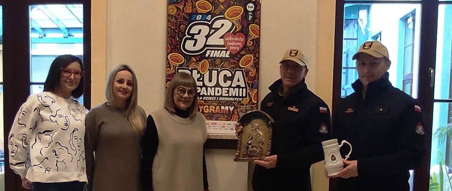 Zdjęcie przedstawia delegację z KP PSP w Skarżysku-Kamiennej przekazujących przedmioty na licytację podczas 32 finału WOŚP.