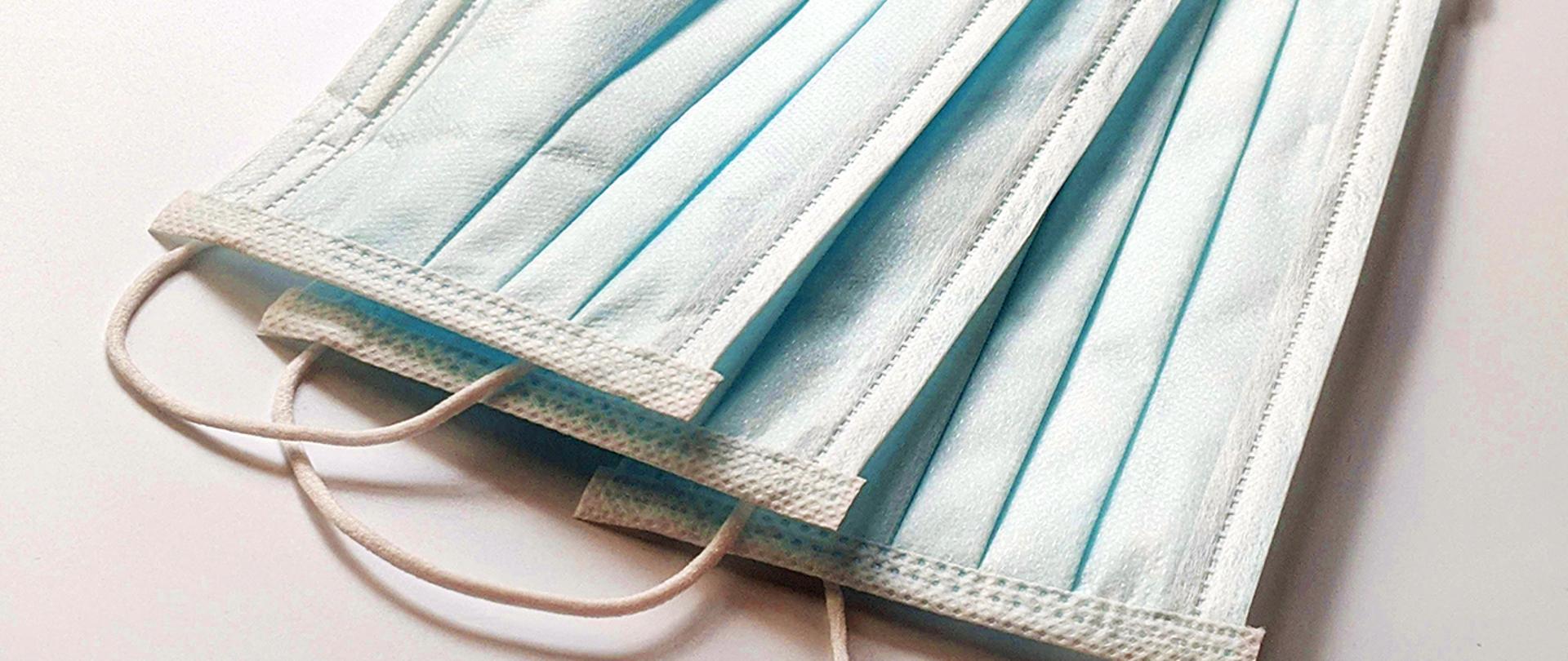 leżący stosik trzech maseczek chirurgicznych.