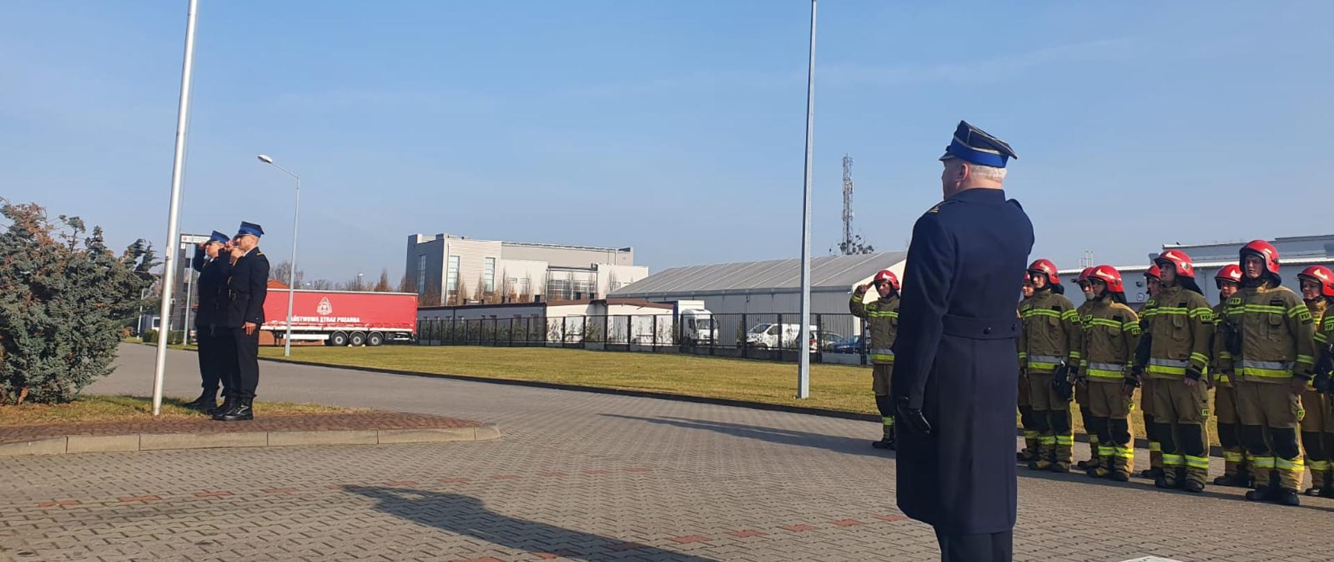 Na placu przed Komendą, poczet flagowy, Komendant oraz zmiana służbowa JRG śpiewa Hymn Narodowy podczas wciągania flagi na maszt, jednocześnie salutując.