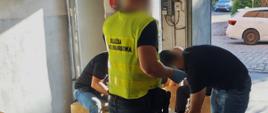 Funkcjonariusze Służby Celno-Skarbowej sprawdzają kartony z towarem.