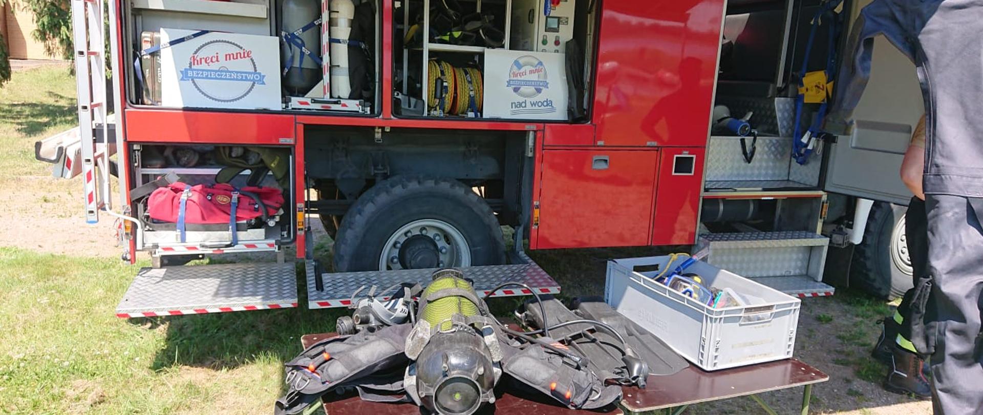 Zdjęcie przedstawia samochód ratownictwa wodnego z otwartymi skrytkami, wyjętym sprzętem.