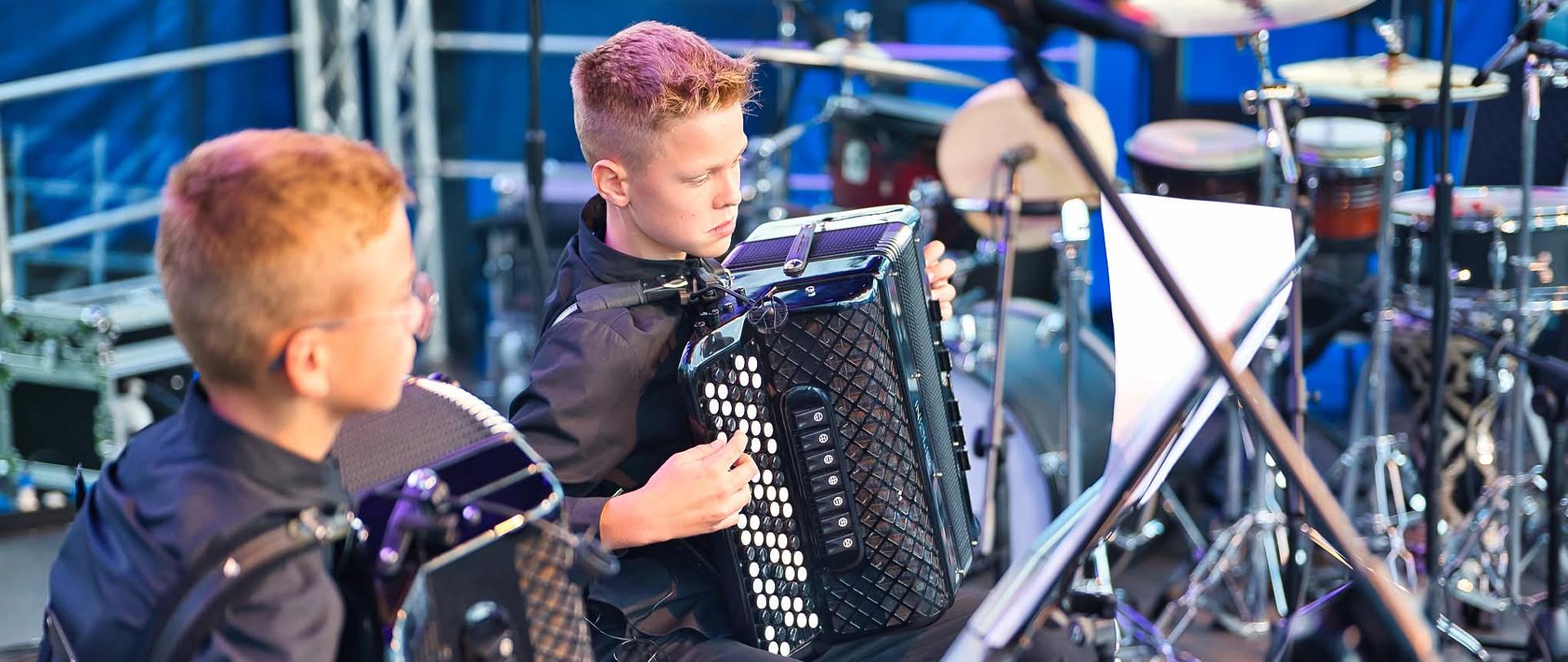 Duet akordeonowy podczas występu na scenie.