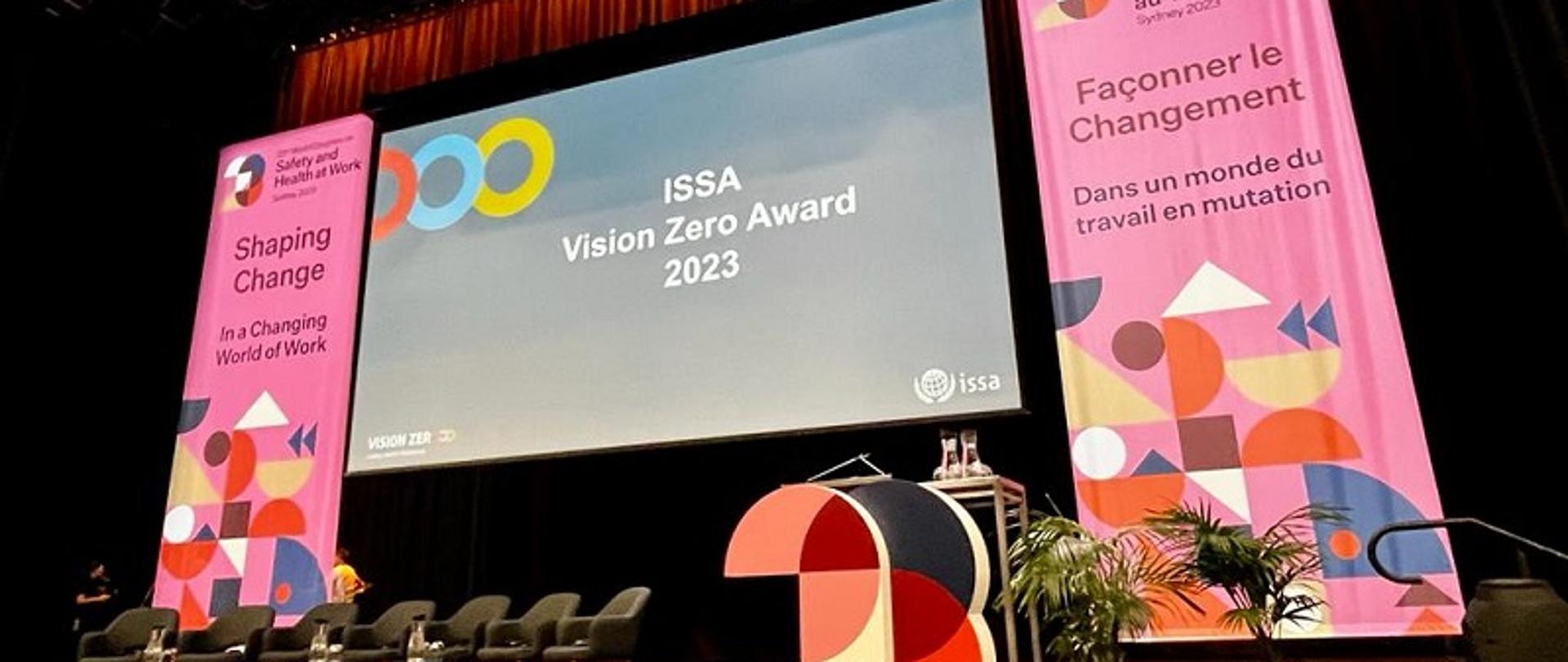 Scena z ekranem z informacją o nagrodzie ISSA Vision Zero Award 2023