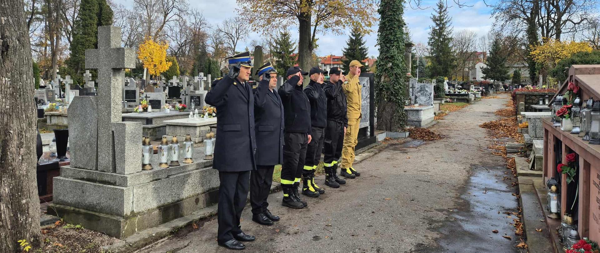 Strażacy oddają hołd, przed grobem poległych.