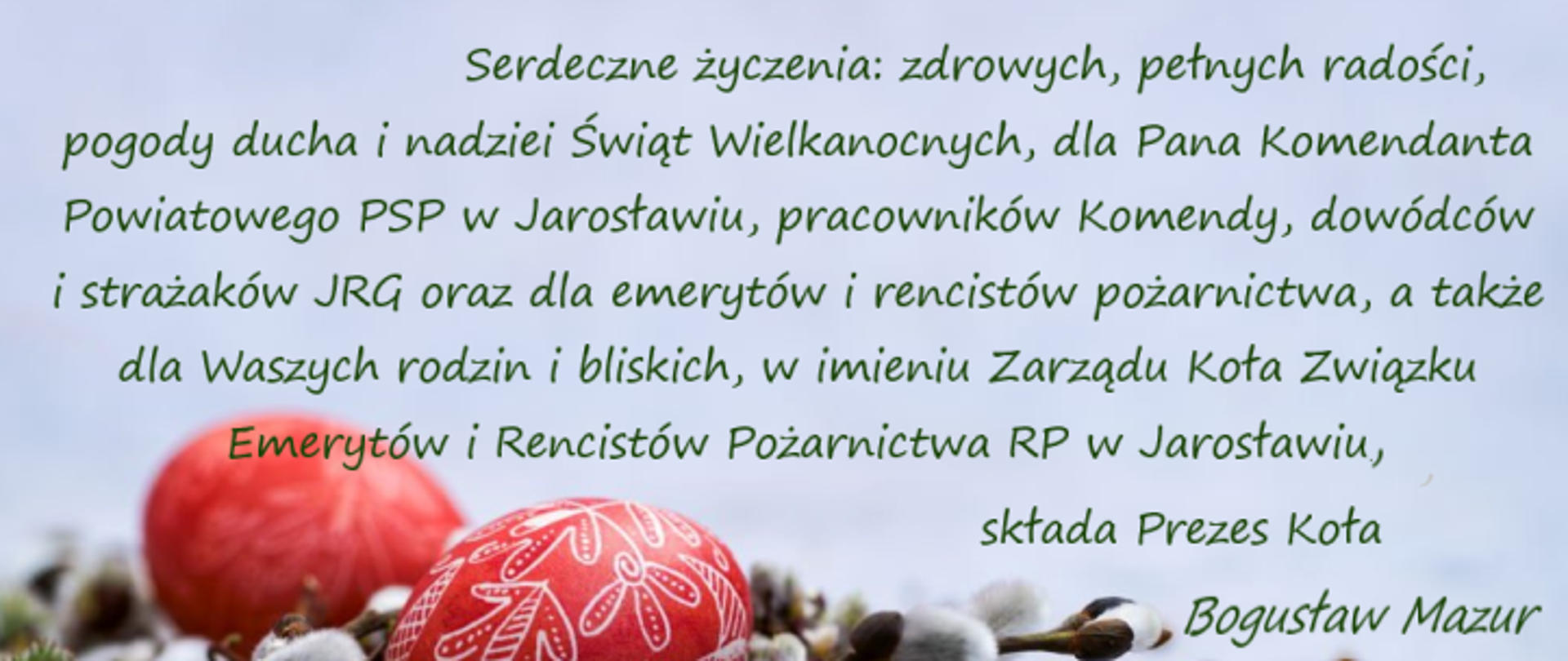 Grafika z życzeniami wielkanocnymi na tle wiosennej aranżacji z czerwonymi pisankami i baziami. Tekst zawiera życzenia zdrowia, radości, pogody ducha i nadziei z okazji Świąt Wielkanocnych, skierowane do Komendanta Powiatowego PSP w Jarosławiu, pracowników komendy, dowódców i strażaków JRG, a także emerytów, rencistów oraz ich rodzin. Podpis: Prezes Koła – Bogusław Mazur.