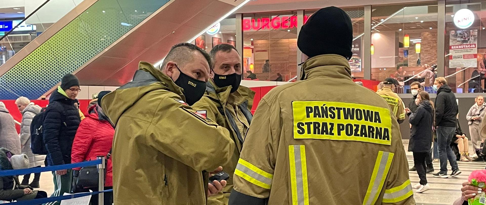 Strażacy wewnątrz dworca podczas narady