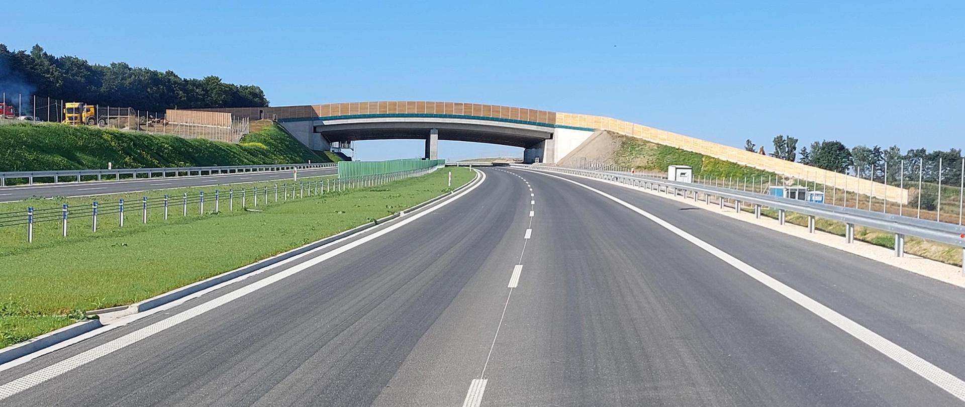 Droga ekspresowa S7 na odcinku Moczydło - Miechów tuż przed udostępnieniem do ruchu. Na zdjęciu dwie jezdnie drogi ekspresowej po dwa pasy ruchu w każdym kierunku. Trwają prace wykończeniowe.