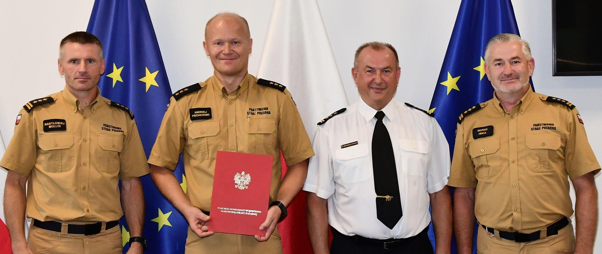 Czterech strażaków stojących w szeregu