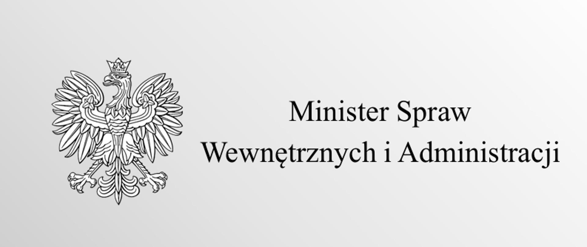 Na zdjęciu po lewej stronie orzeł z godła polskiego, po prawej napis Minister Spraw Wewnętrznych i Administracji. Wszystko na biało-szarym tle.