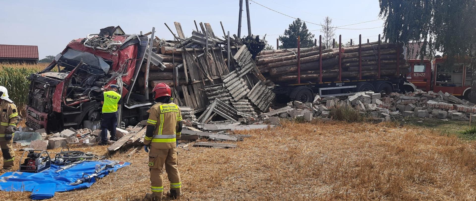 Na zdjęciu widać rozbity pojazd ciężarowy oraz przedstawicieli służb ratowniczych 