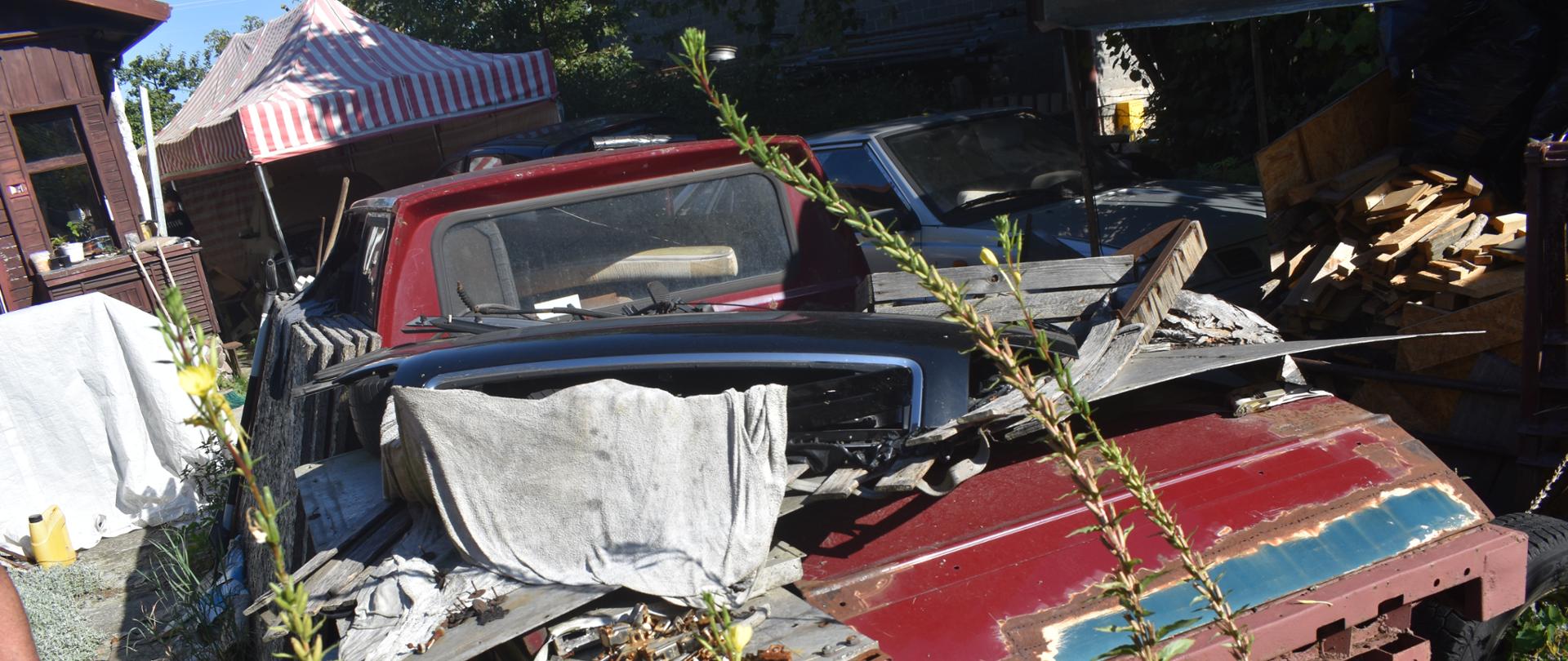 Karoseria i części samochodowe leżące na otwarty terenie.