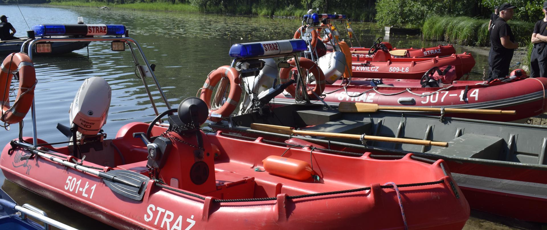 Zdjęcie przedstawia łodzie ratownicze z jeziorem w tle