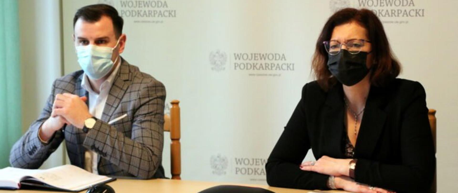 Od lewej zastępca dyrektora Wydziału Bezpieczeństwa i Zarządzania Kryzysowego Jakub Dzik i wojewoda podkarpacki Ewa Leniart przy stole prezydialnym podczas posiedzenia wojewódzkiego Zespołu Zarządzania Kryzysowego.