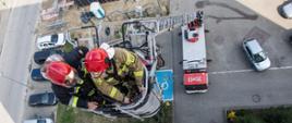 Zdjęcie przedstawia strażaków operujących drabiną mechaniczną z kosza podczas ćwiczeń.