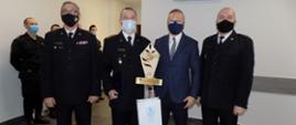 st. bryg. Jacek Kaczamarek, st. bryg. Grzegorz Łydkowski, mł. asp. Rafał Raczkowski z wyróżnieniami, starosta Jarosław Sochacki. W tle inni strażacy.