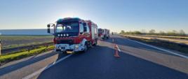 Na zdjęciu znajdują się ustawione na jezdni samochody strażackie