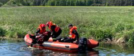 Ćwiczenia w ramach doskonalenia zawodowego na rzece. Trzech strażaków wykonuje ćwiczenia na pontonie.