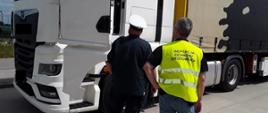 Inspektorzy kontrolują przewoźników na drodze.