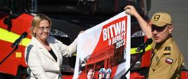 Minister Anna Moskwa wraz z Komendantem Głównym PSP prezentują plakat "Bitwa o remizy"