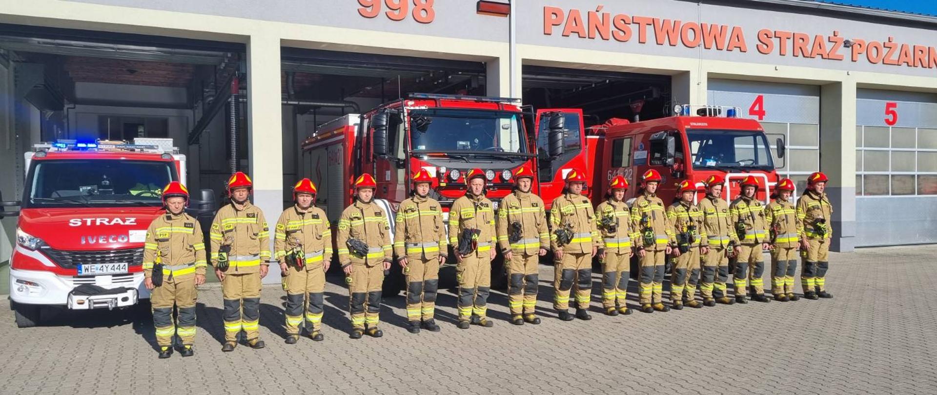 Sokołowscy strażacy oddali hołd strażakowi Komendy Głównej PSP, który zginął w wypadku podczas służby - na zdjęciu strażacy w ubraniu specjalnym na placu przed strażnicą na zbiórce w szeregu przed czerwonymi samochodami strażackmi