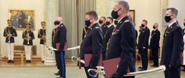 strażacy stojący w umundurowaniach galowych trzymający szable generalskie , w tle osoby towarzyszące