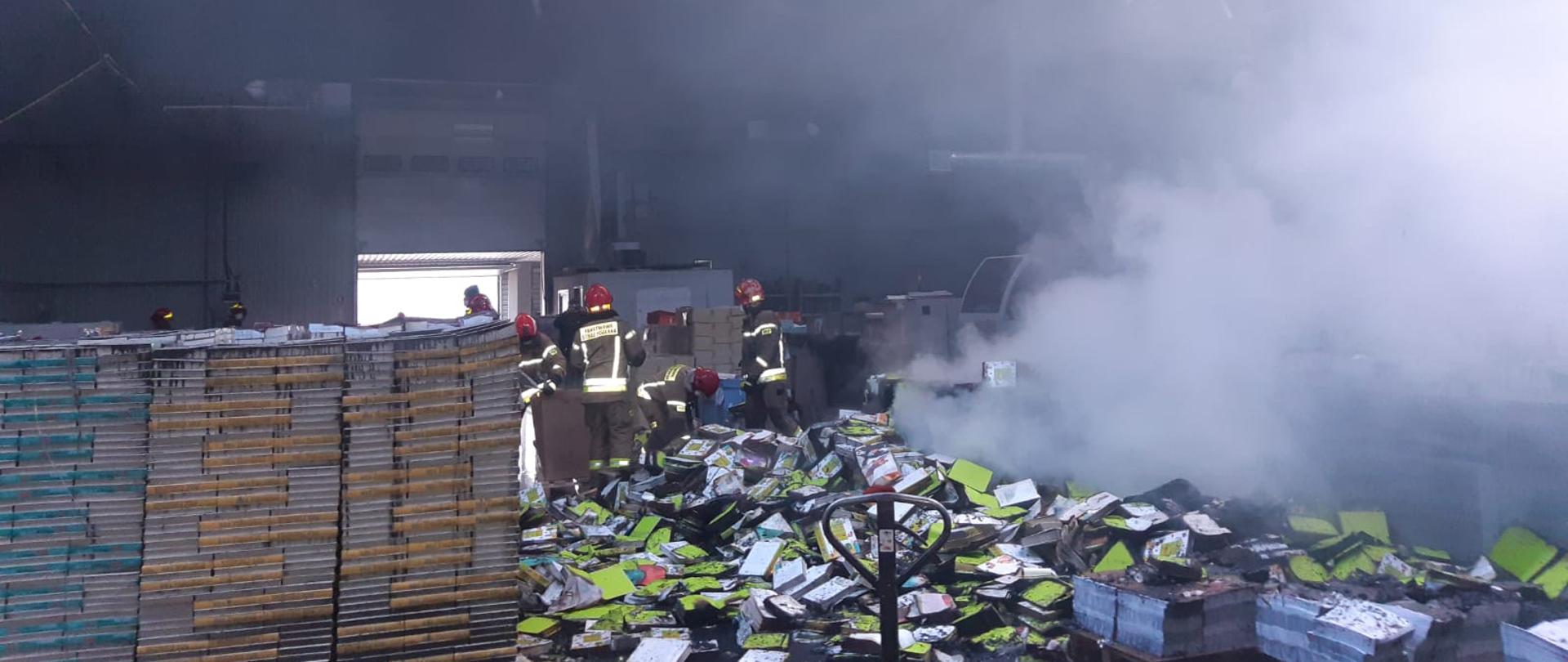 Zdjęcie przedstawia ratowników wewnątrz obiektu objętego pożarem