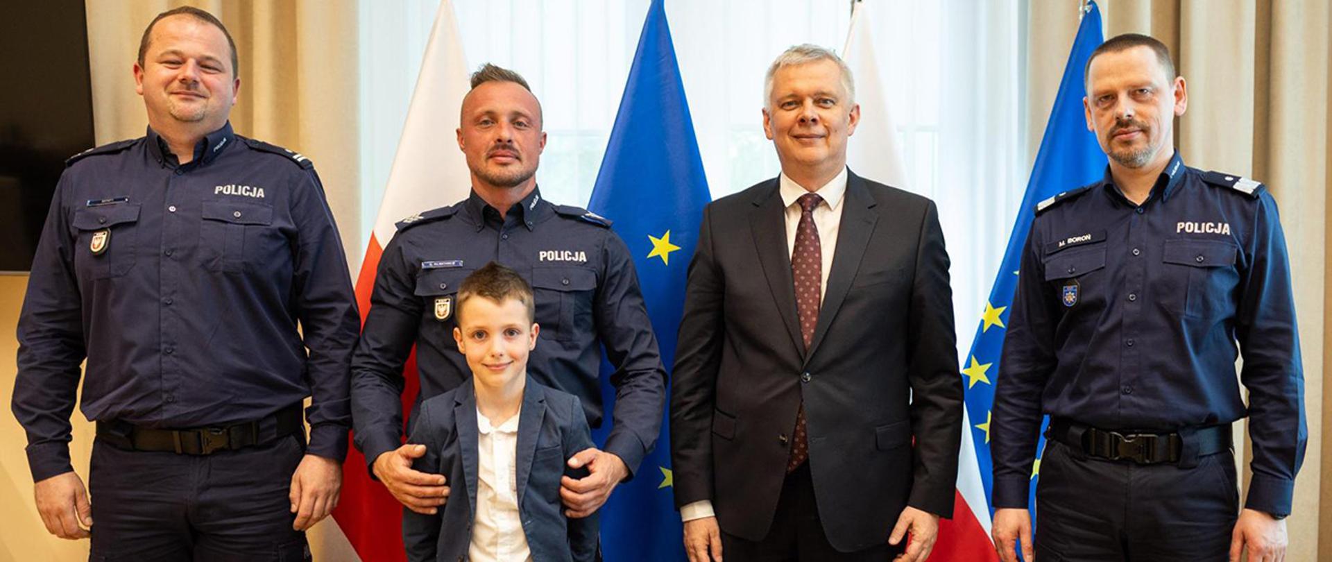 Na zdjęciu uczestnicy spotkania pozują do zdjęcia na tle flag Polski i Unii Europejskiej