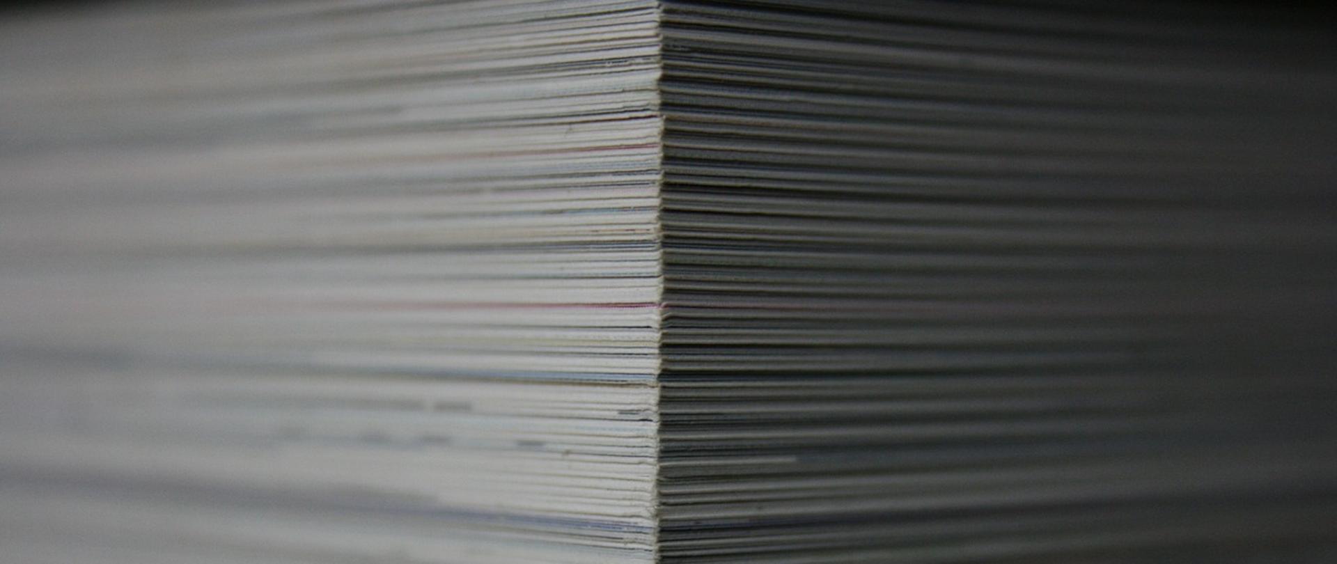 Zdjęcie ilustracyjne w poziomie. Stos białych teczek