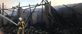 Palą się budynki gospodarcze, strażak gasi pożar w sprzęt ODO