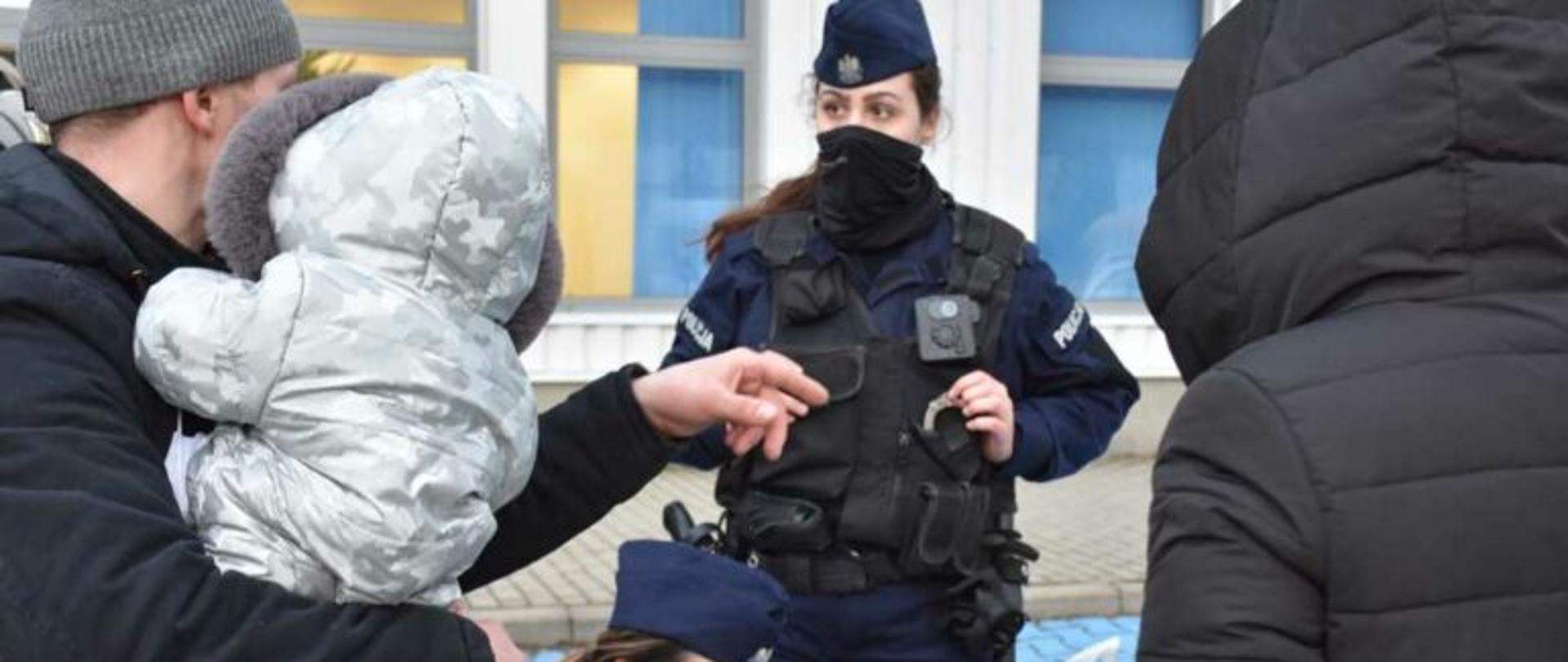 Funkcjonariuszka Policji rozmawia z uchodźcami. 