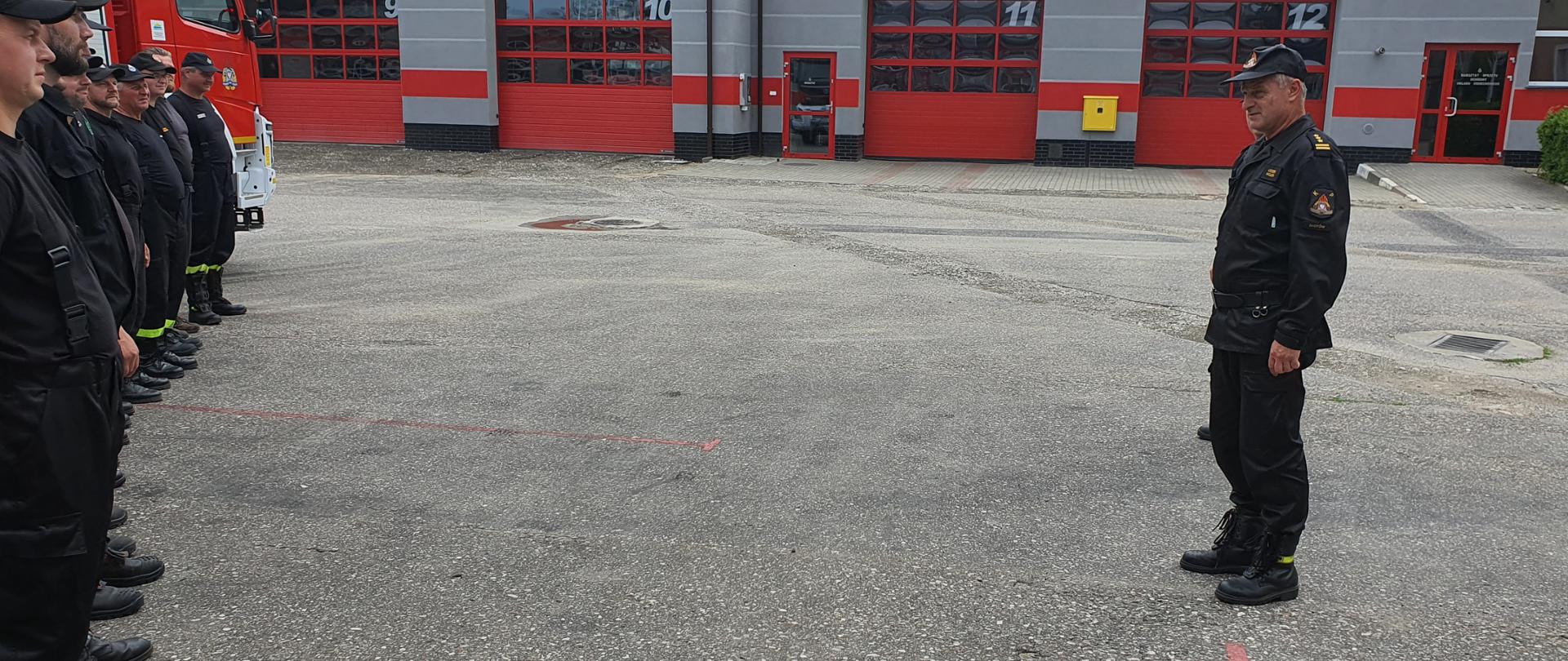 Na zdjęciu widoczny na pierwszym planie zastępca Komendanta Powiatowego w Złotowie st.bryg. Leszek Wójcik w tle widoczne są garaże JRG po lewej stronie zdjęcia widoczni są uczestnicy kursu.