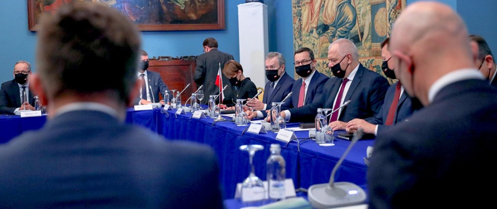 Stosunki polsko-litewskie konsultacje rządowe. Przy stole siedzą przedstawiciele obu rządów. W środku premier Mateusz Morawiecki. Obok niego po prawej wicepremier Jacek Sasin.