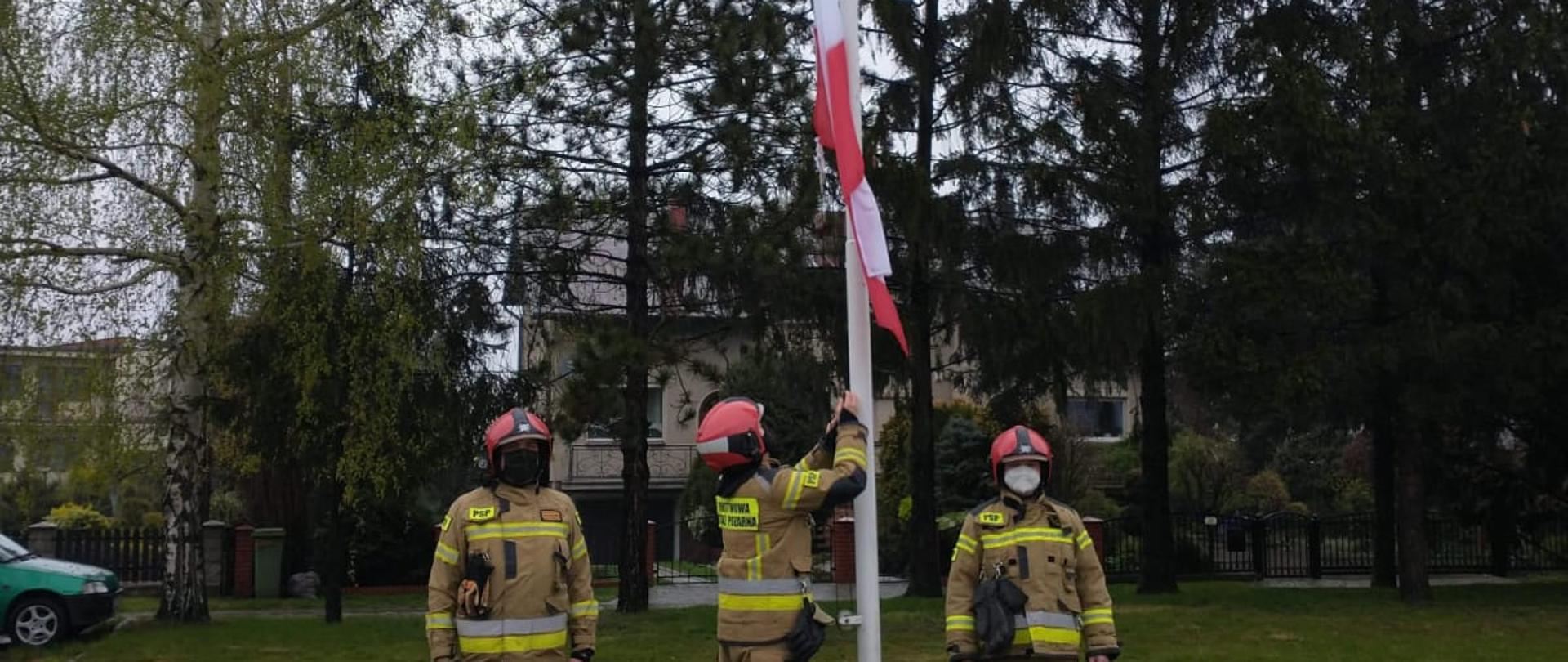 Strażacy wciągający flagę na maszt