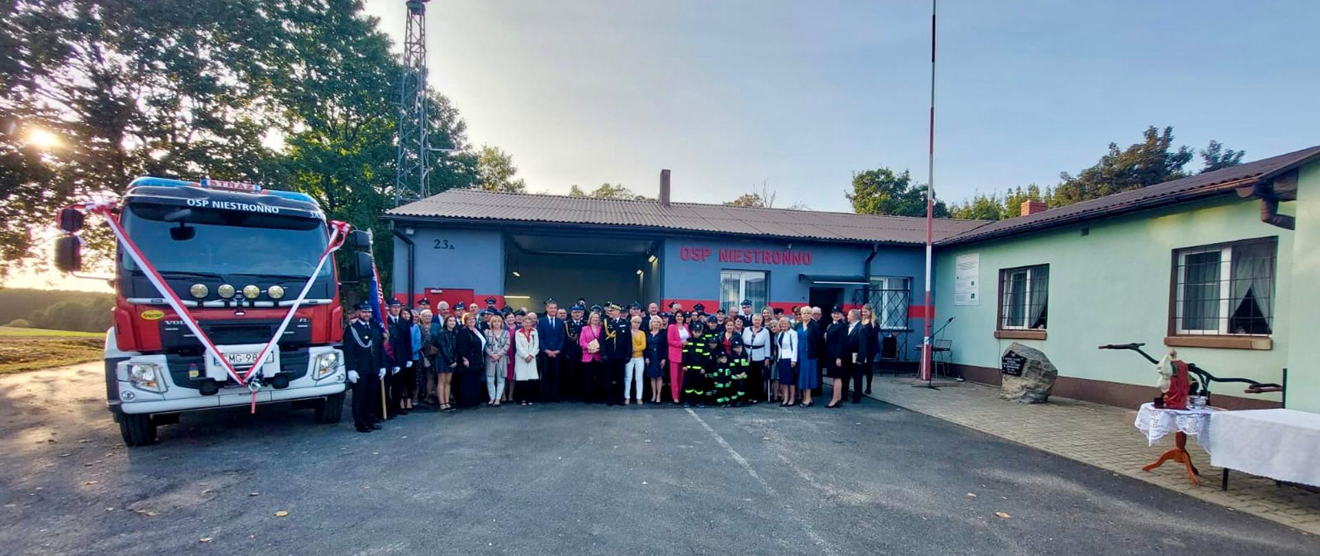 Na zdjęciu znajdują się uczestnicy oficjalnego przekazania średniego samochodu ratowniczo-gaśniczego dla OSP Niestronno. W pierwszym rzędzie znajduje się Kujawsko-Pomorski Komendant Wojewódzki PSP nadbryg. Jacek Kaczmarek, Komendant Powiatowy PSP w Mogilnie st. bryg. Radosław Gałczyński, Pani Poseł na Sejm RP Ewa Kozanecka, Burmistrz Gminy Mogilno Pan Leszek Duszyński