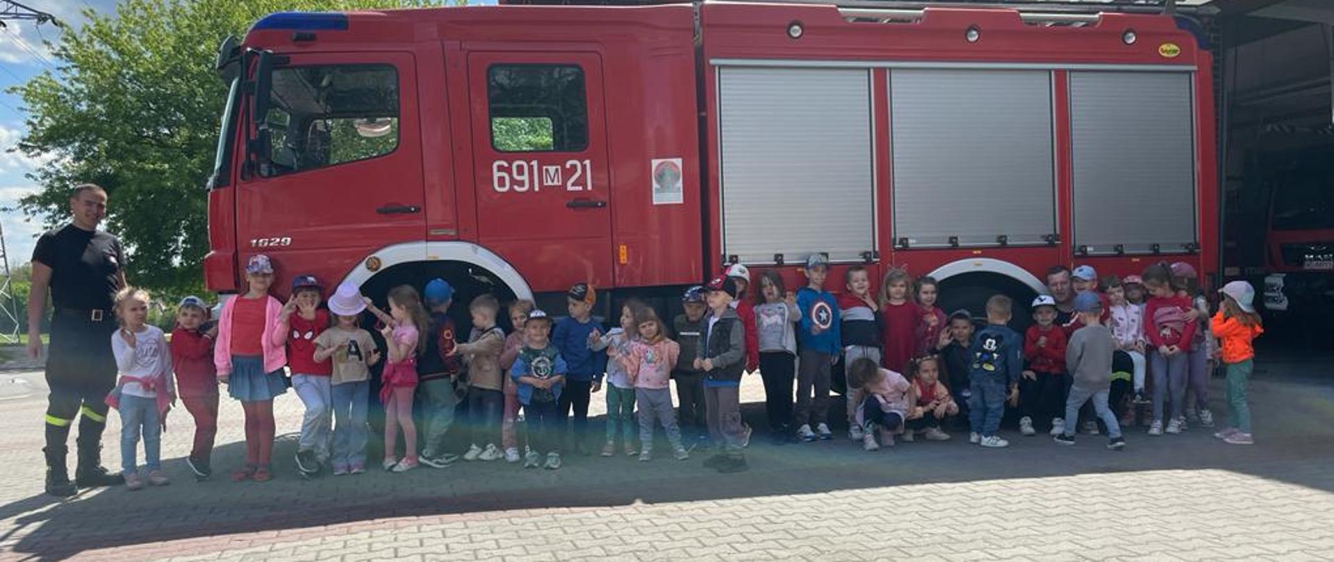 Zdjęcie grupowe dzieci na tle samochodu strażackiego