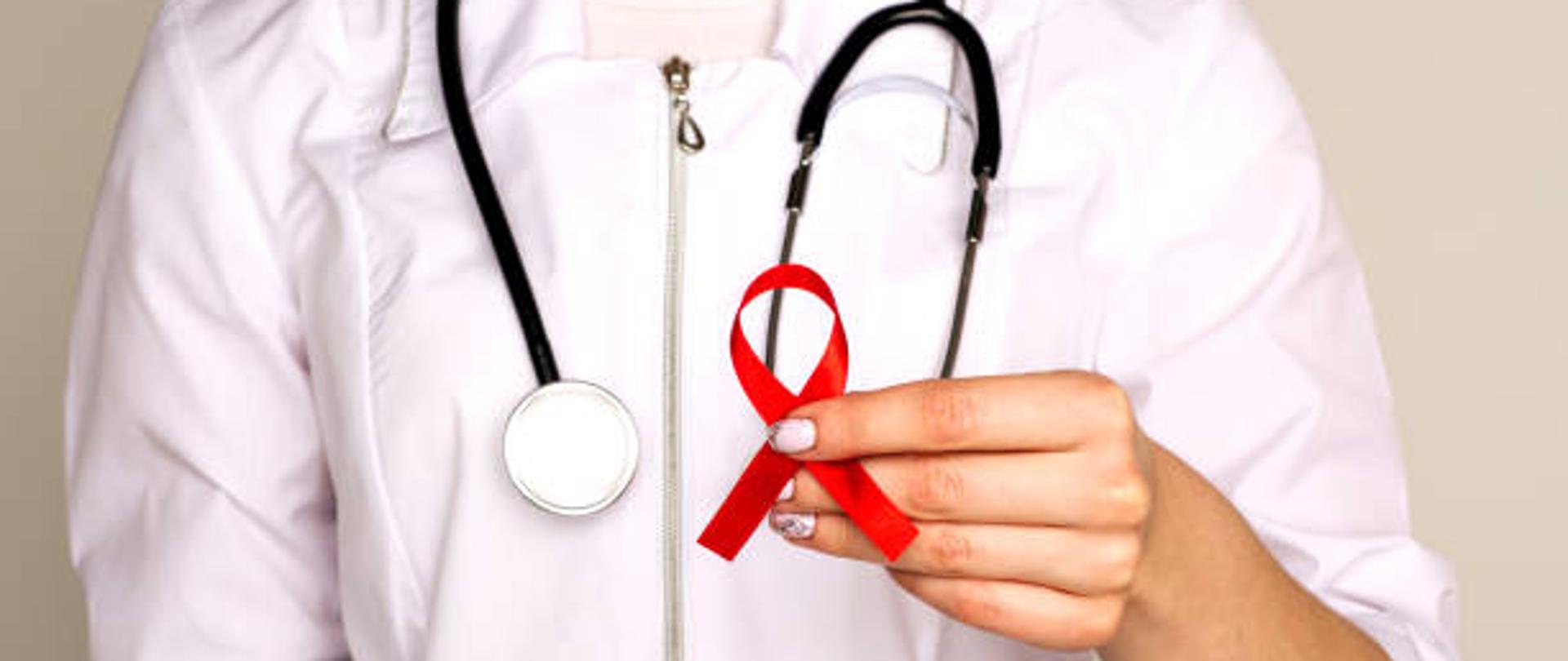 Female doctor withAID, HIV red ribbon. Cancer concept. Doctor Holds Red Ribbon to awareness world aids day Dec. 1. - Image