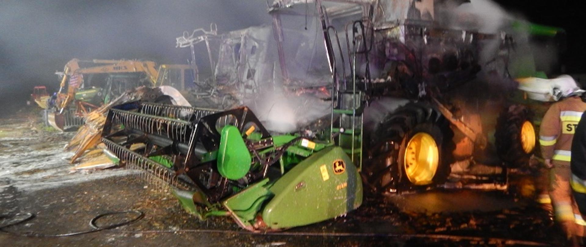 
Zdjęcie przedstawia dwa kombajny zbożowe, które uległy spaleniu.