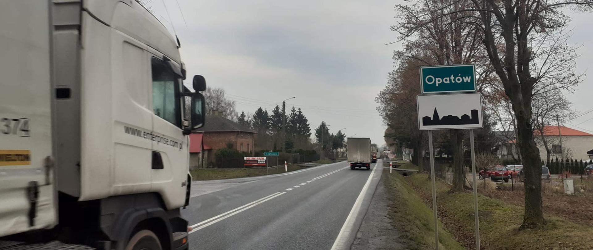Wjazd do Opatowa (jednojezdniowa droga, ciężarówka, tablica z nazwą miasta i oznakowanie terenu zabudowanego) 