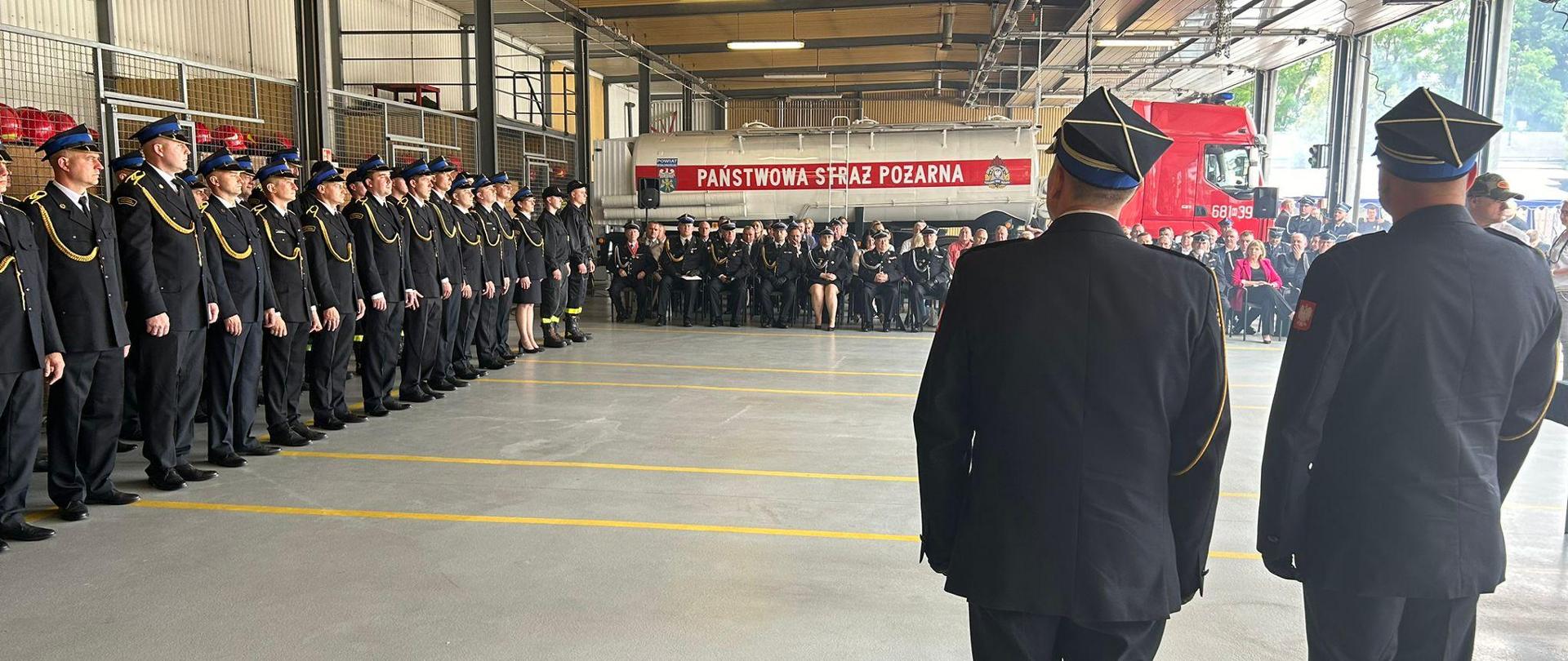 Zdjęcia przedstawiają uroczystą zbiórkę z okazji obchodów dnia strażaka w KP PSP Wołomin oraz 60 lecia istnienia zawodowej straży pożarnej w Wołominie. Na zdjęciach widoczni są strażacy w umundurowaniu wyjściowym w garażu JRG