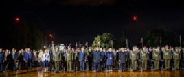 Żołnierze przedstawiciele służb mundurowych oraz zaproszeni goście stoją na baczność podczas uroczystości.