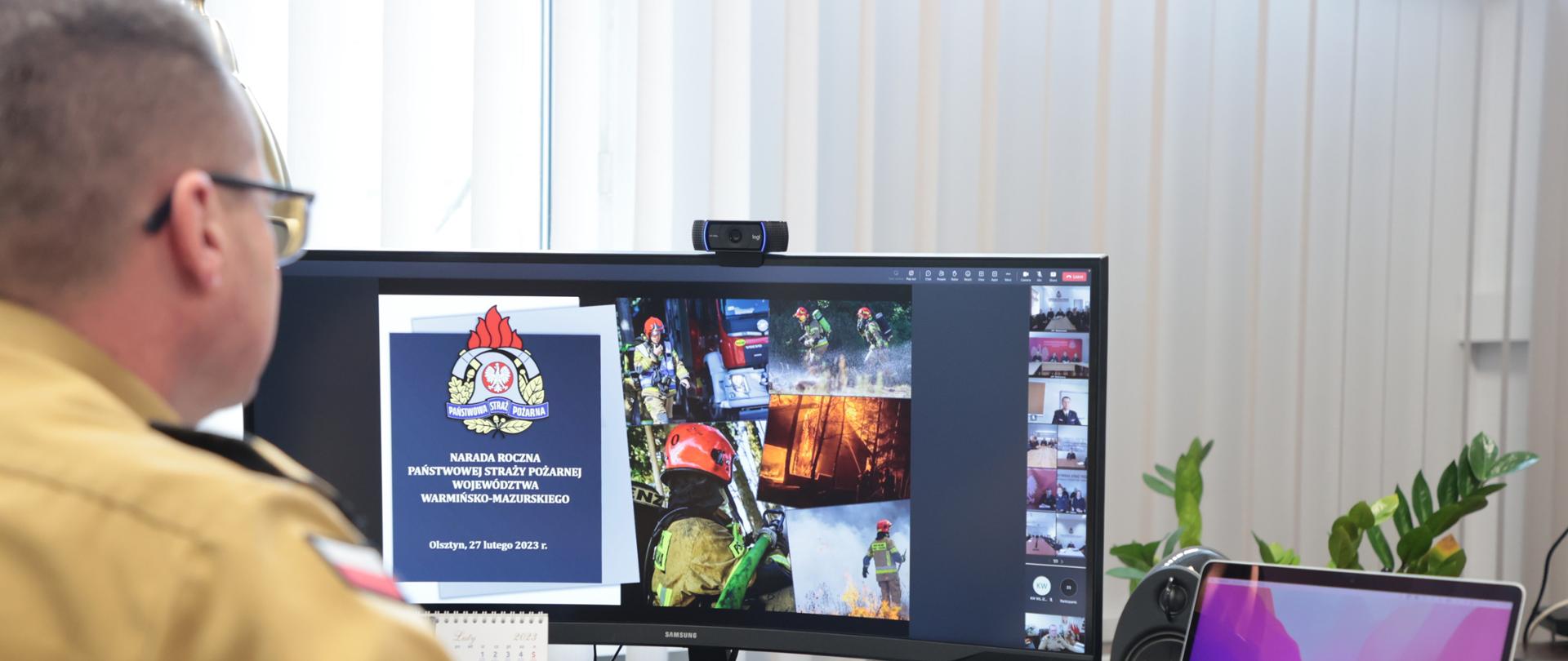 Widok z zza pleców. Komendant w trakcie połączenia z uczestnikami narady