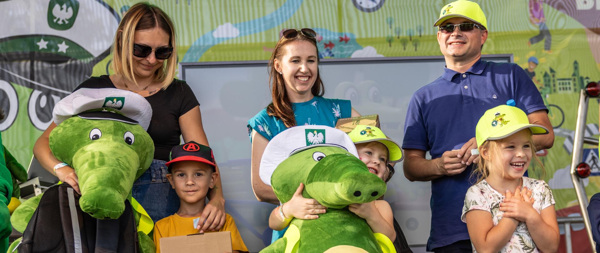 Troje dorosłych i troje dzieci. Wszyscy się uśmiechają. Dzieci otrzymały nagrody za udział w konkursie, w tym duże maskotki Krokodylka Tirka.