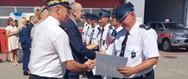 Zdjęcie przedstawia druhów, strażaków oraz gości podczas wręczenia promes dla OSP i PSP